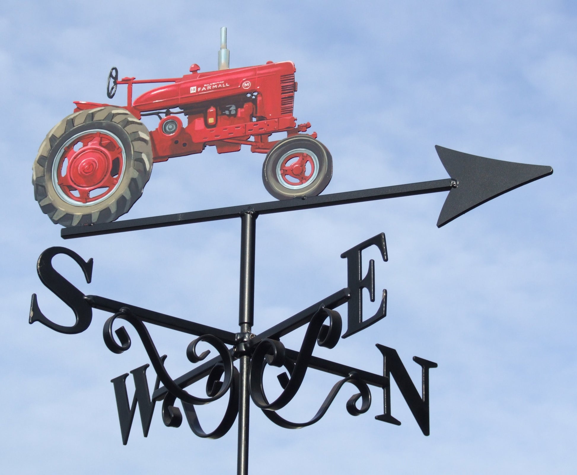 A Farmall tractor hand painted red depicting a weather vane